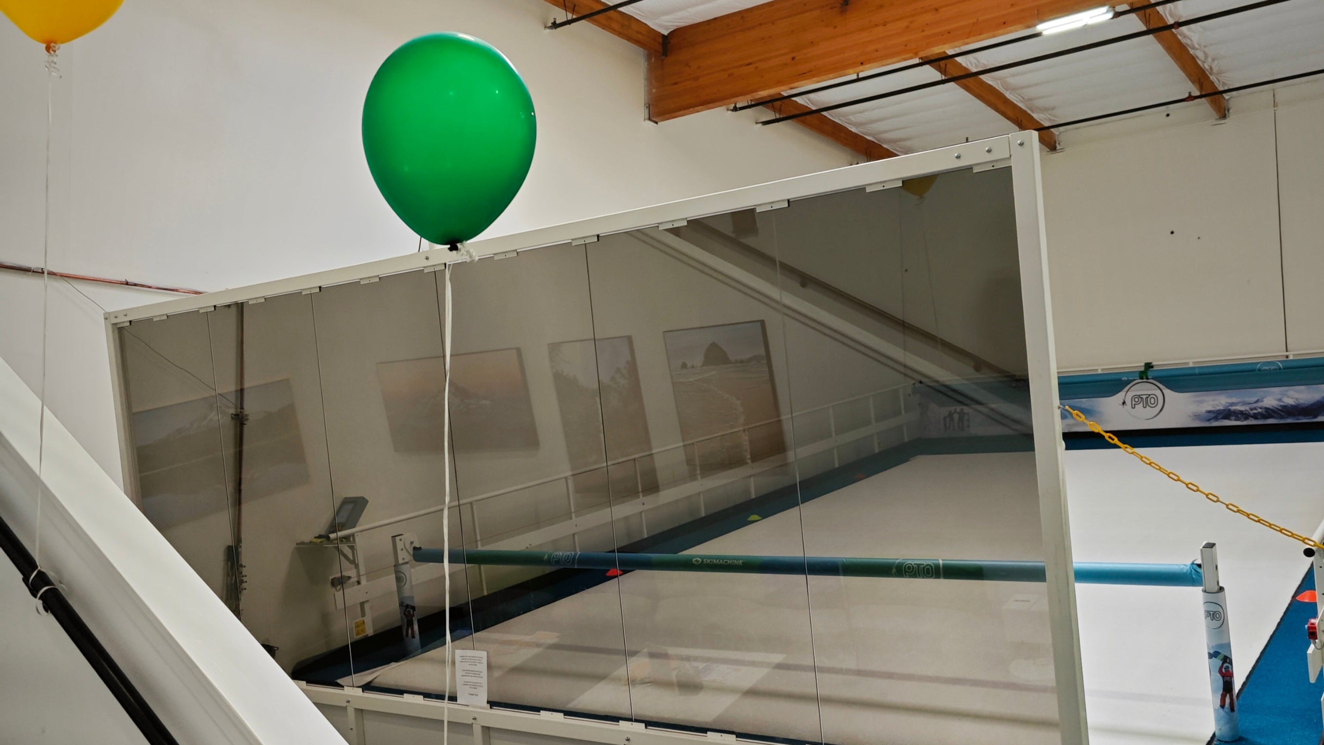 Green balloon floating near a staircase with a pool table in the background.